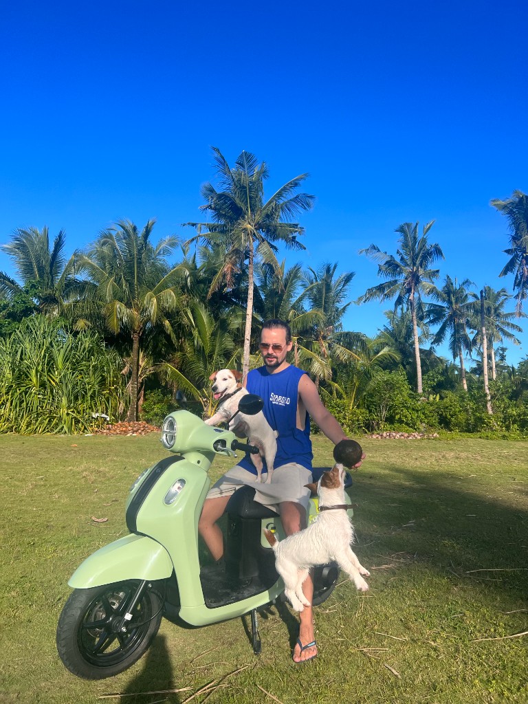 Scooter delivery anywhere in Siargao - man with dogs and coconut